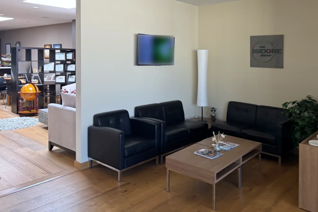 The reception and waiting area of The Isidore Group headquarters in Burr Ridge, with black leather seating, a coffee table, and the company logo on the wall